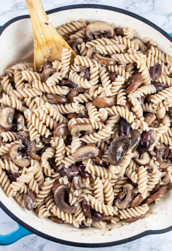 Mushroom and olive pasta combined in skillet.